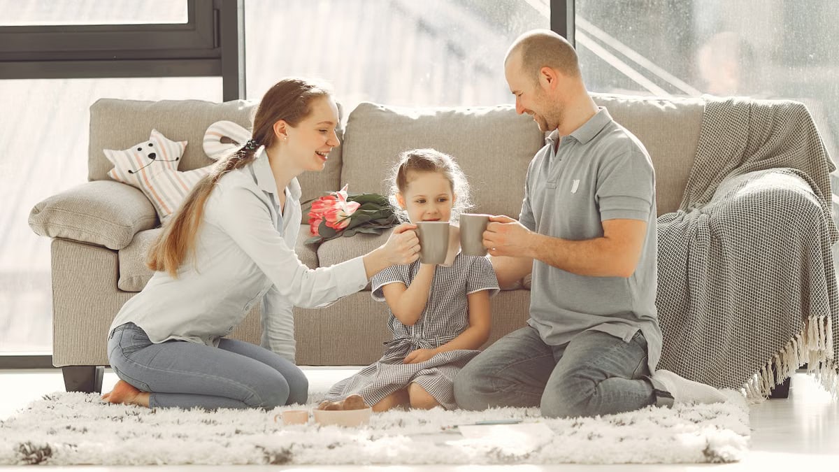 A joyful family enjoying quality time and coffee in a bright living room, symbolizing love and togetherness.